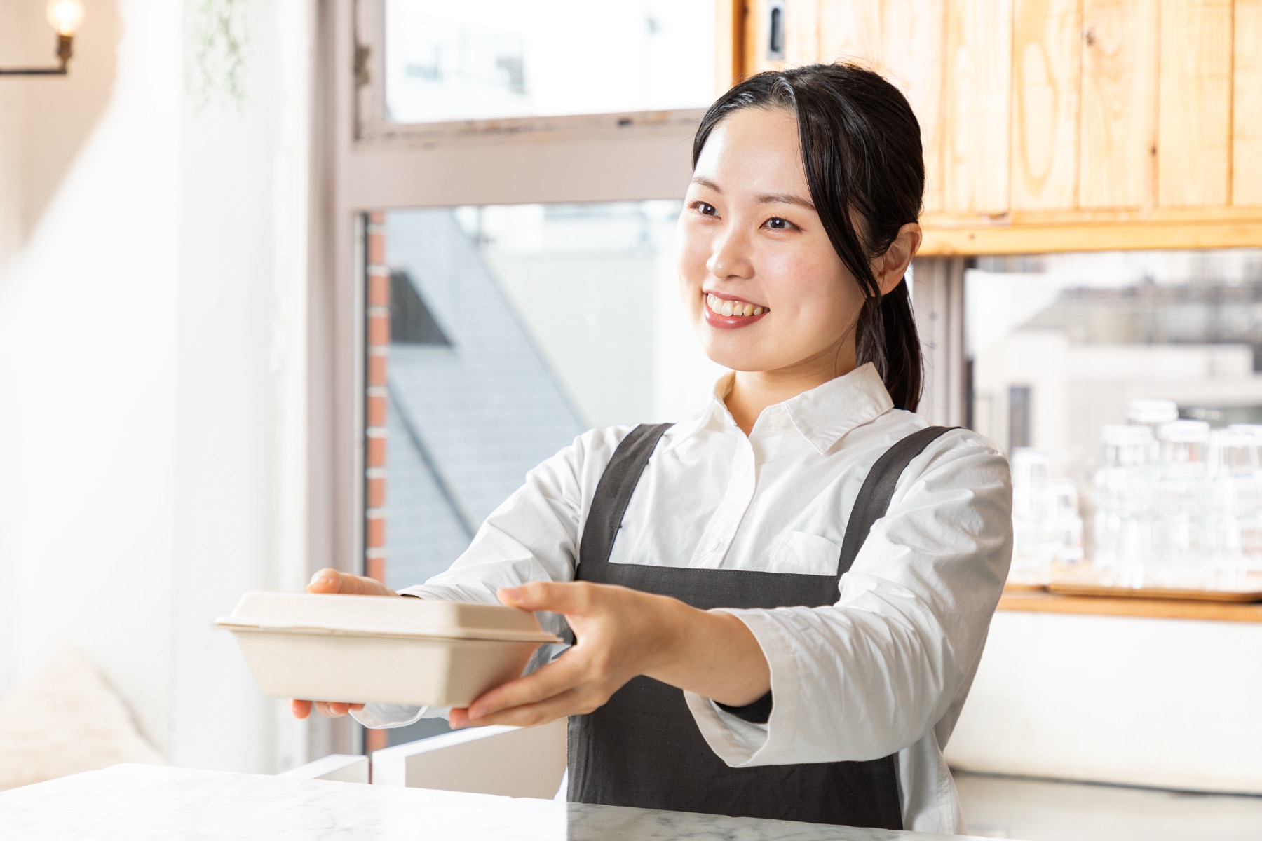 お弁当を笑顔で手渡すうさぎやのスタッフ